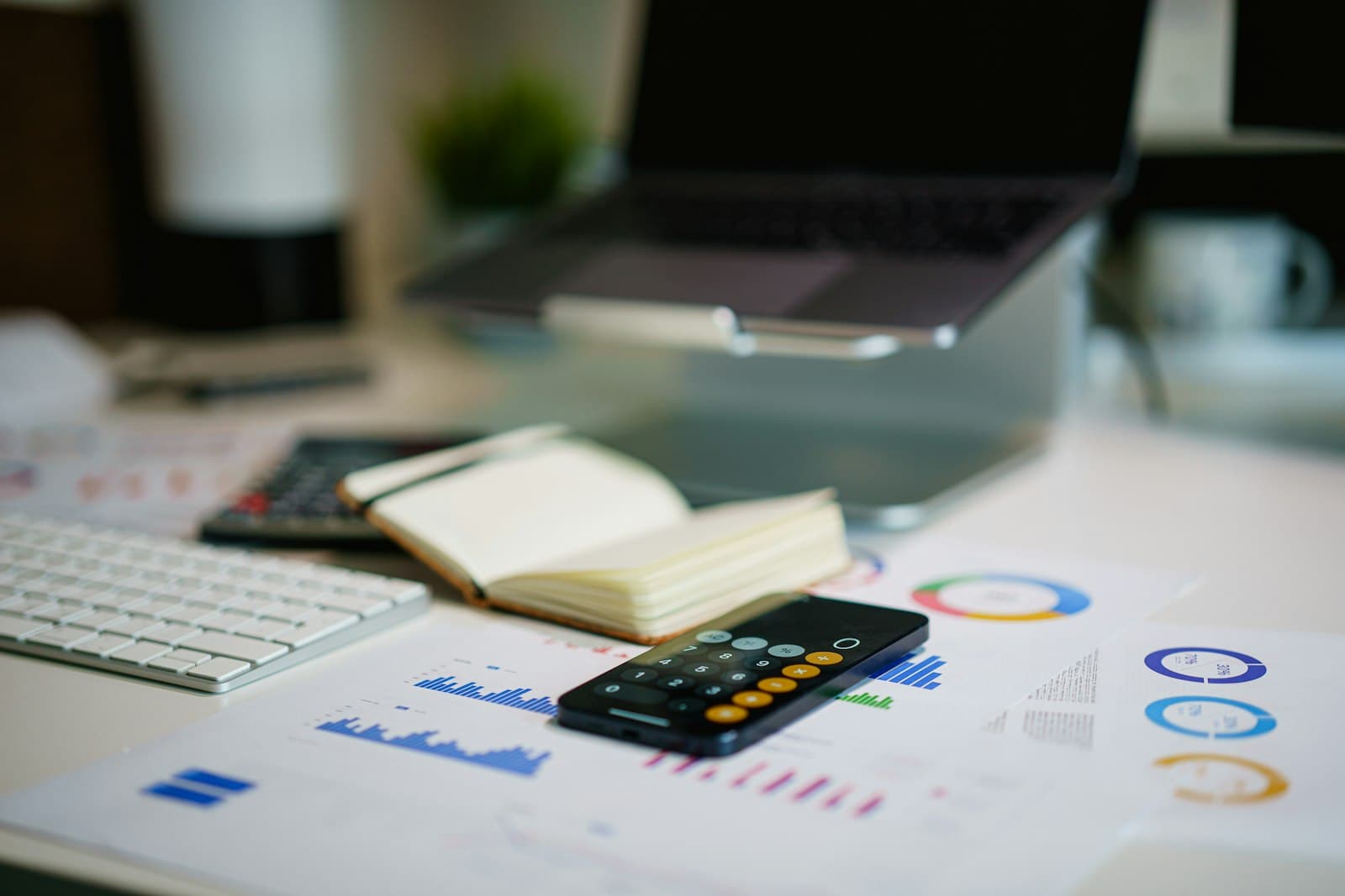 Spreadsheet of accounting line items with a calculator and pen