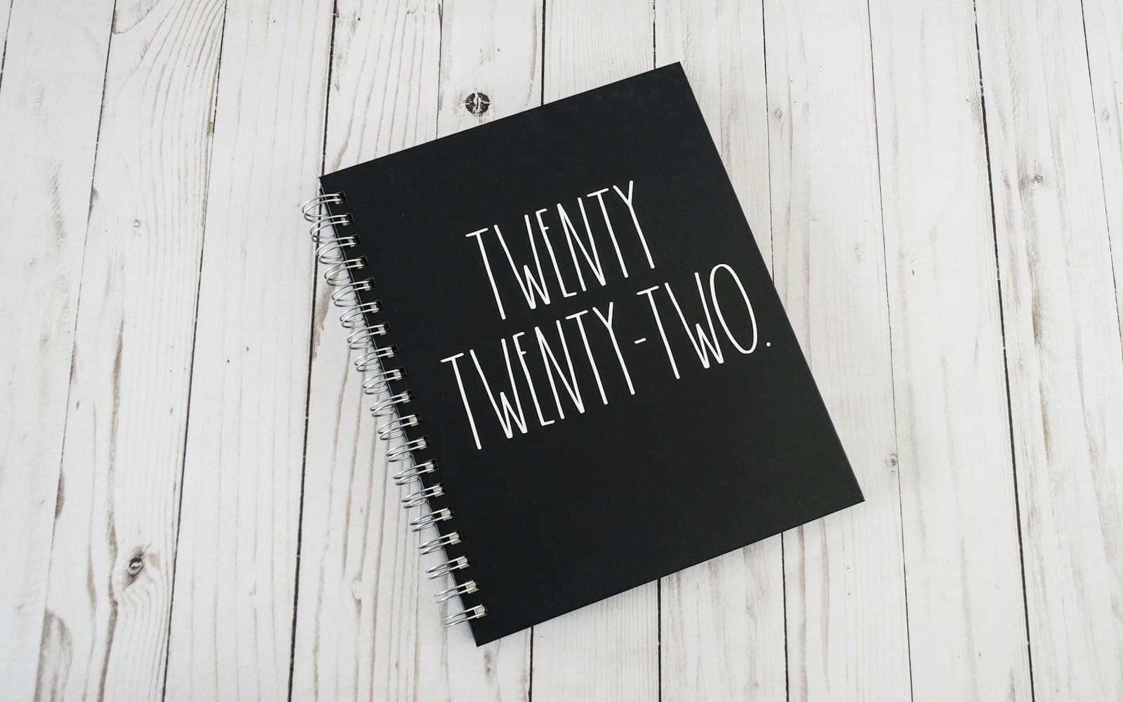 Open paper planner with handwritten dates and a pen on a desk